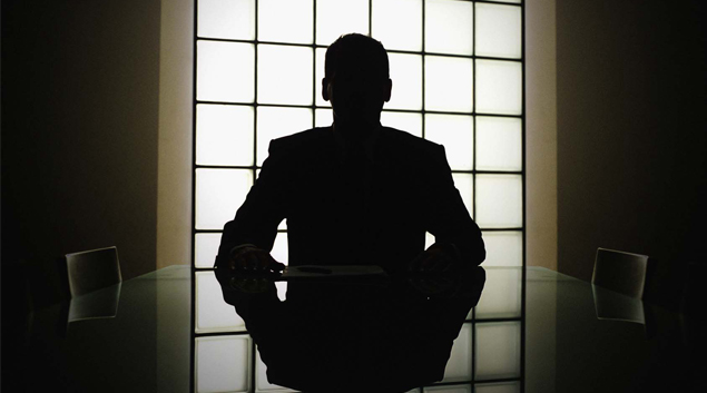 Silhouette of person staring out of a window