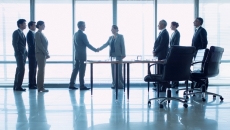 Businesspeople greeting in a lobby. (Photo by Martin Barraud/Getty Images)