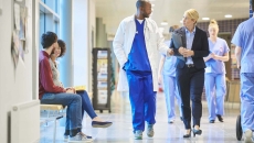 Physicians and others walking in hospital corridor