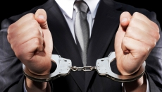 Handcuffed hands in a suit