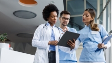 Healthcare professionals in a lobby with a clipboard