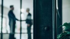 Two people greet in office building lobby