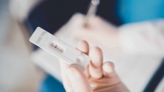 A COVID-19 test strip in a hand