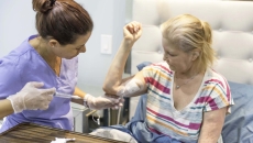 Health professional injecting patient