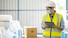 Person with clipboard in a warehouse. Photo: Nitat Termmee/Getty Images