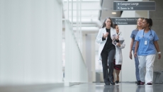 Healthcare professionals walk through a hospital corridor