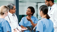 Group of doctors standing in a huddle talking