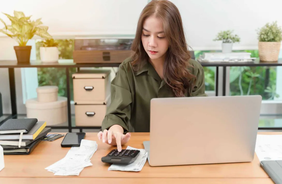 Person using a calculator and a computer Person using a calculator and a computer