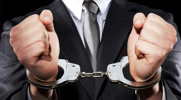 Handcuffed hands in a suit