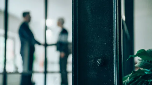 Two people greet in office building lobby