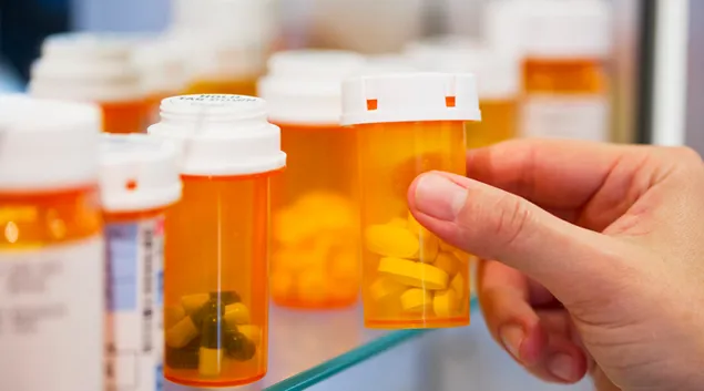 Hand and pill bottles