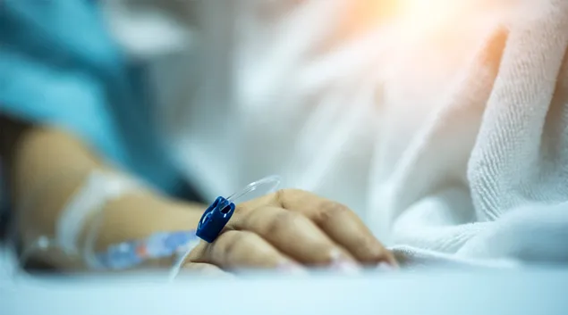 An arm with an IV and a sensor