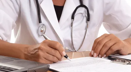 Doctor signing a piece of paper
