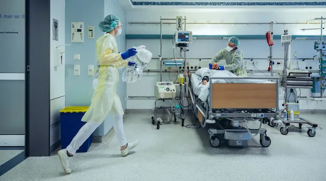 healthcare workers caring for a patient in a hospital