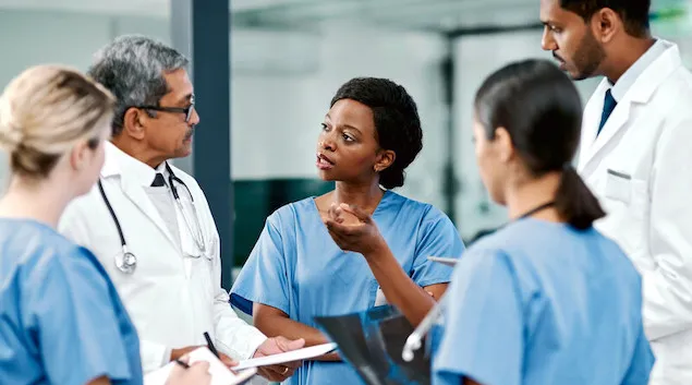 Group of doctors standing in a huddle talking