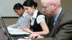 Three people work at computers