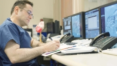 Doctor in front of several computer screens.