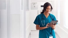 Person in scrubs types in tablet