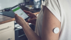 Person with health tracker on arm and associated mobile app Photo: dzika_mrowka/Getty Images