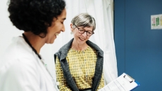 Senior patient meeting with their doctor and looking at forms on a clipboard