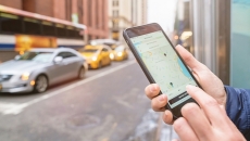 Hand hold smartphone near line of cars