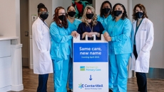 People behind a CenterWell standing sign