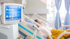 A screen with readings next to an occupied hospital bed