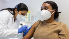Healthcare worker in mask vacinating patient in mask