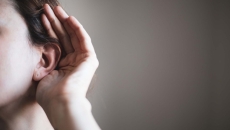 A person cupping an ear