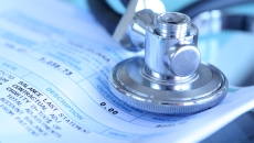 A stethoscope resting on a medical bill