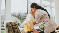 Person with back pain being helped out of a chair