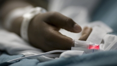 A person's hand in a hospital bed (Photo: rubberball/Getty Images)