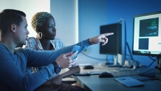 Workers pointing at a computer screen