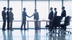 People shaking hands in a boardroom