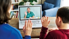 Parent and child waving to provider on laptop screen