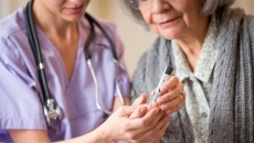 Skilled nurse caring for elderly woman.