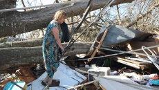 Kathy Coy stands among what is left of her home after Hurricane Michael destroyed it.