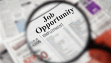 Magnifying glass over newspaper looking for a job