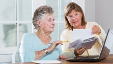 Worker helping senior patient with forms.
