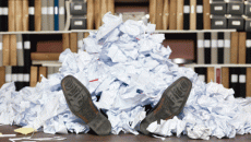 employee buried in paperwork