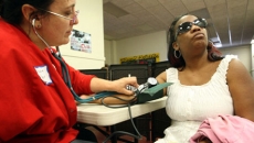 Nurse Allison Miller (L) checks the blood pressure of Keri Anderson in Los Angeles in July 2012. (Getty)
