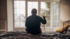Silhouette of senior staring out nursing home window