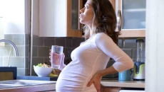Pregnant woman holding glass of water