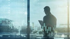 Business person using tablet over shifting stock market image