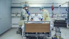 Healthcare workers in PPE care for COVID-19 patient in a hospital