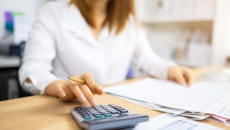 Person with papers and a calculator