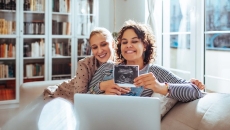 Couple showing ultrasound photo over video call