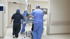 Medical professionals wheeling a patient in a hospital. Photo: Reza Estakhrian/Getty Images