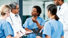 Healthcare professionals in discussion, standing in a circle
