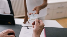 Person handing their ID to another person behind a counter